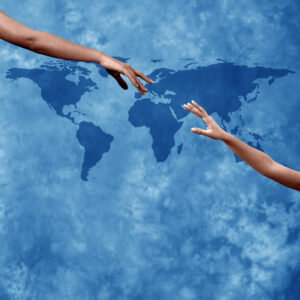 Hands reaching each other across a world map