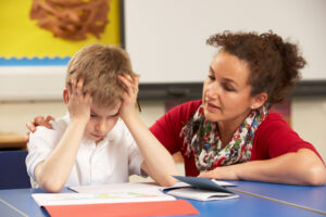 Stressed child studying with teacher